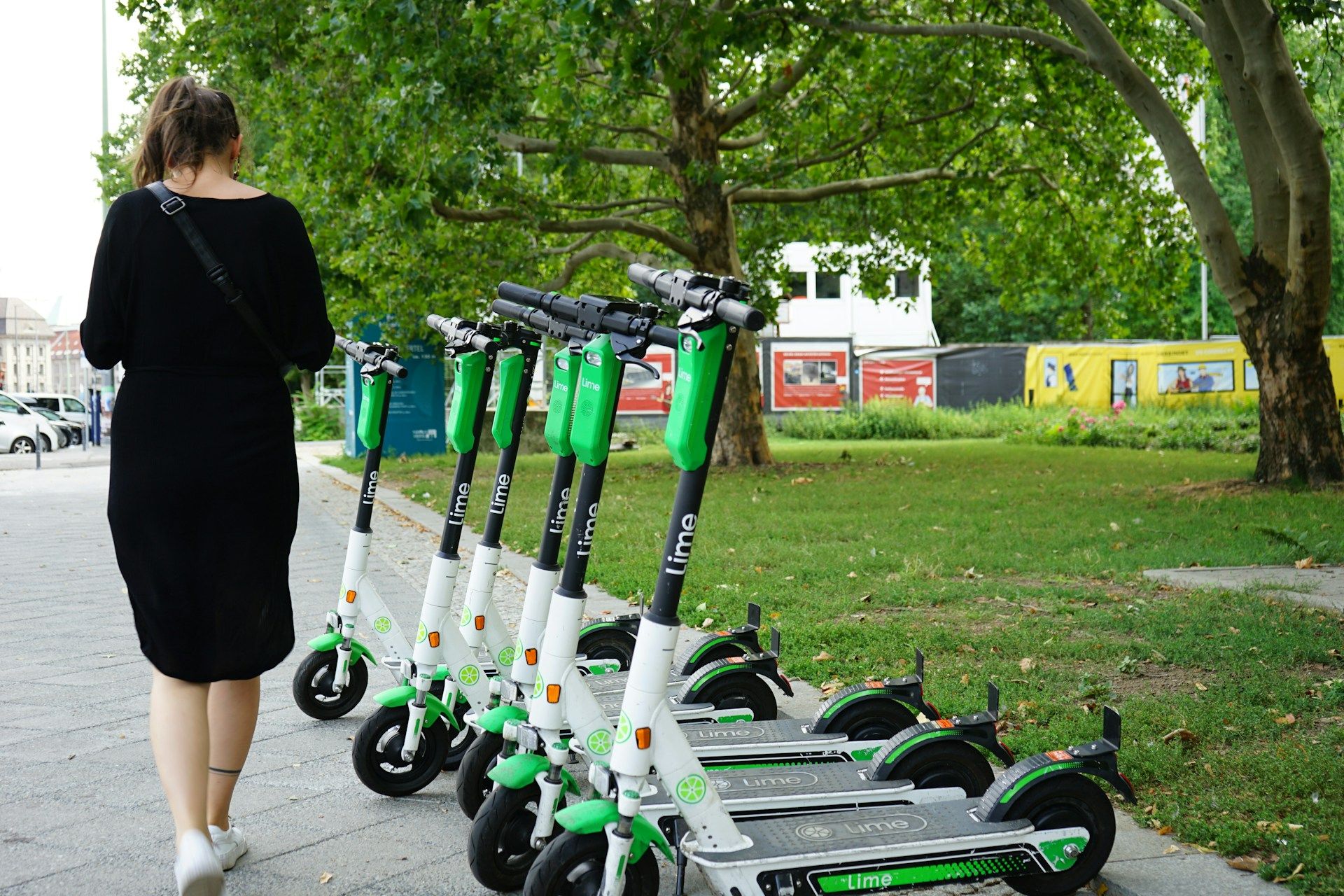 woman walking past parked LIME scooters