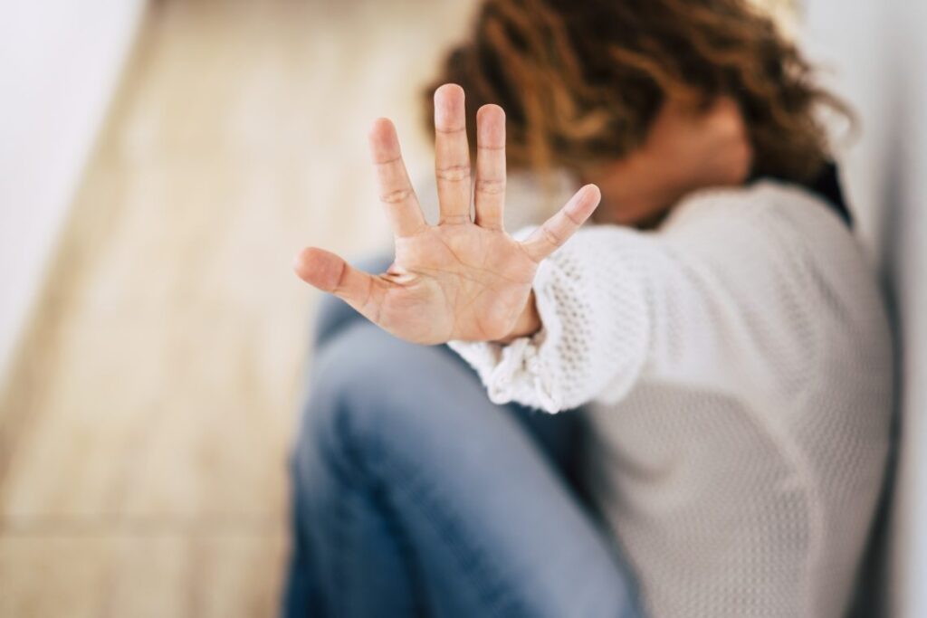 woman shielding her face with her hand