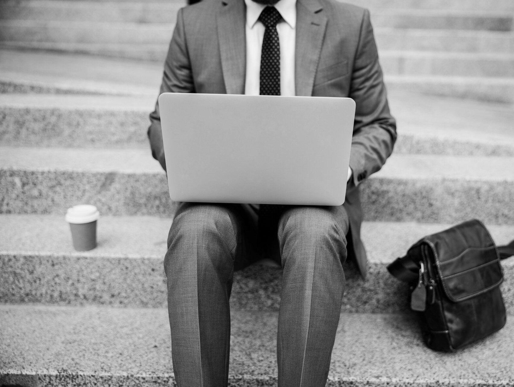 business man working on laptop sitting on steps