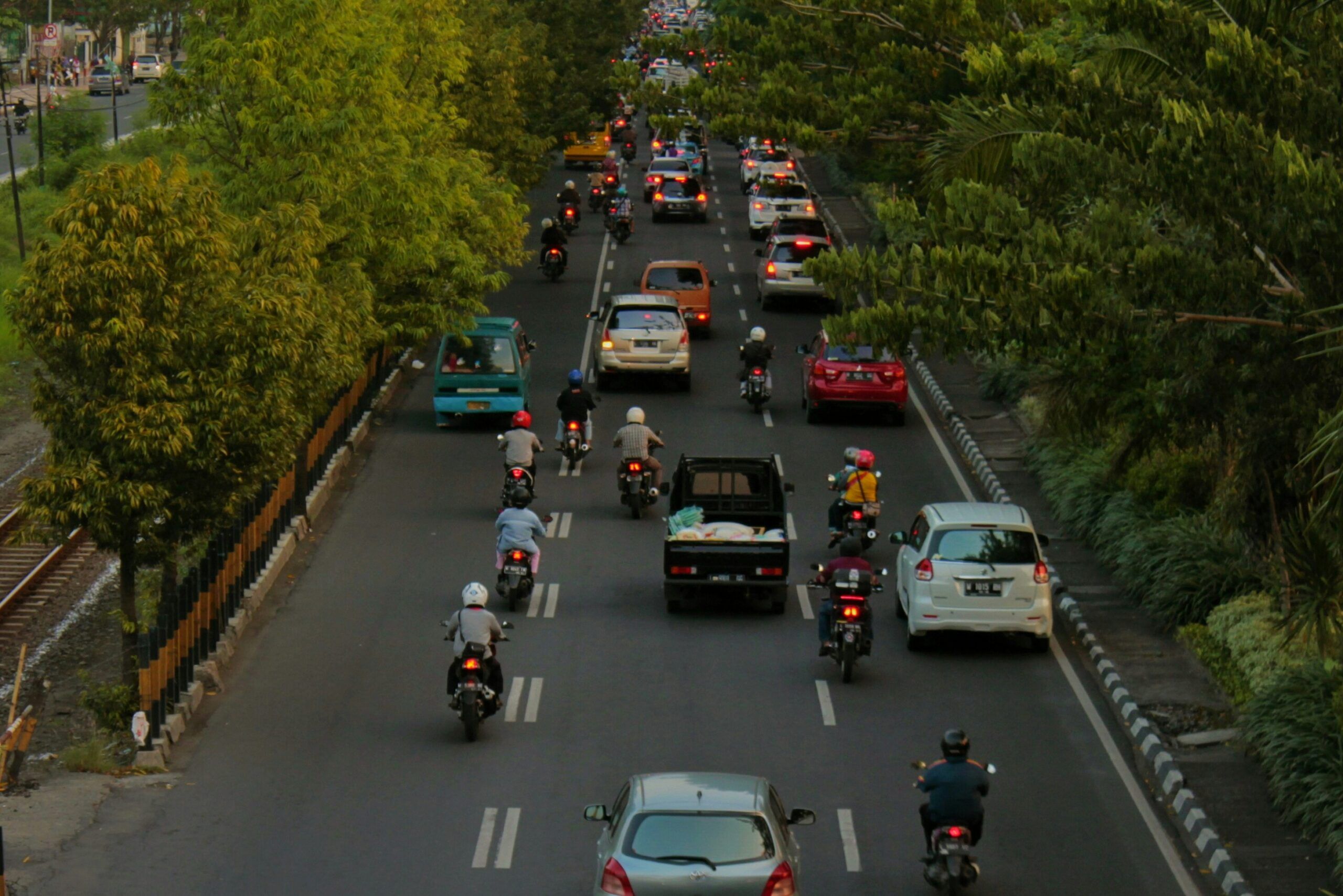 A bustling street filled with numerous cars and motorcycles navigating through traffic.